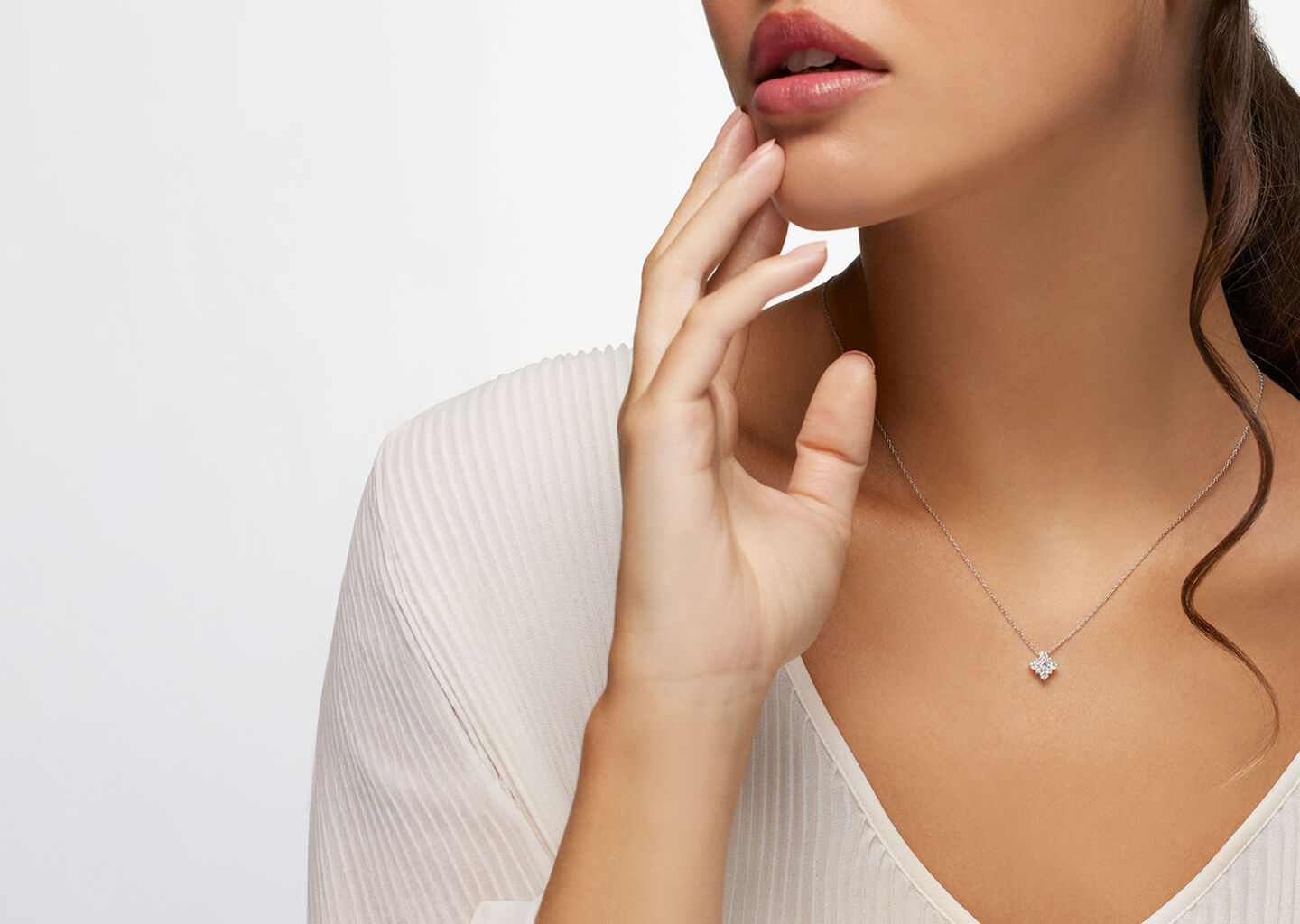 a woman wearing Birks Snowflake diamond necklace.